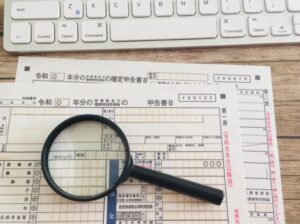 確定申告の申告書と虫眼鏡