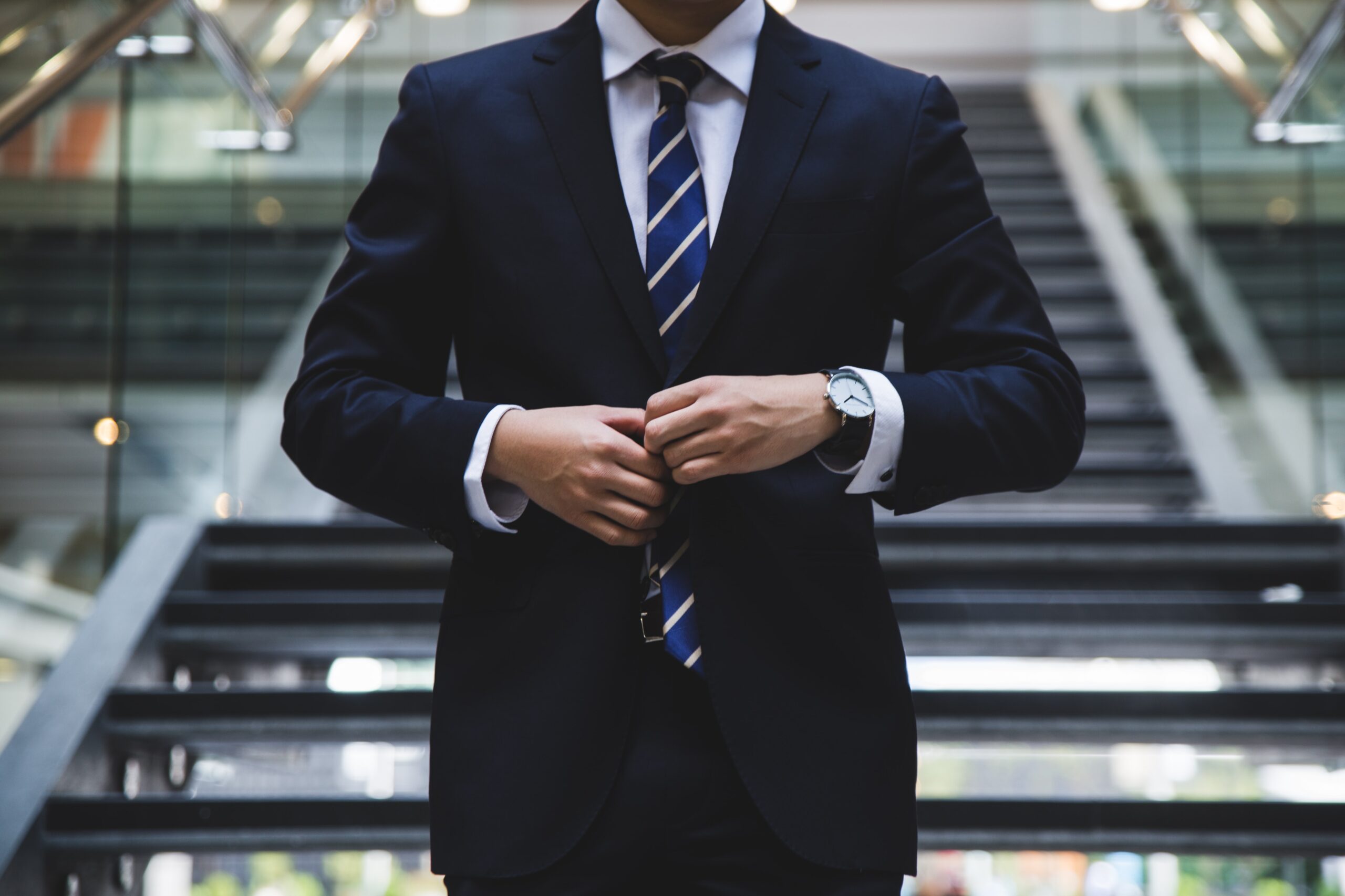 階段の前に立つ会社員の男性